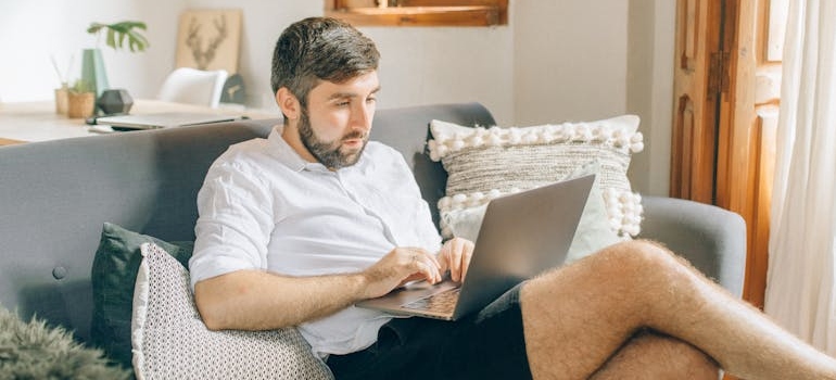 čovek sam kod kuće koristi laptop.