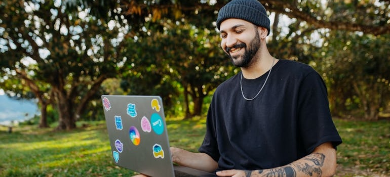 Čovek koristi laptop u parku.